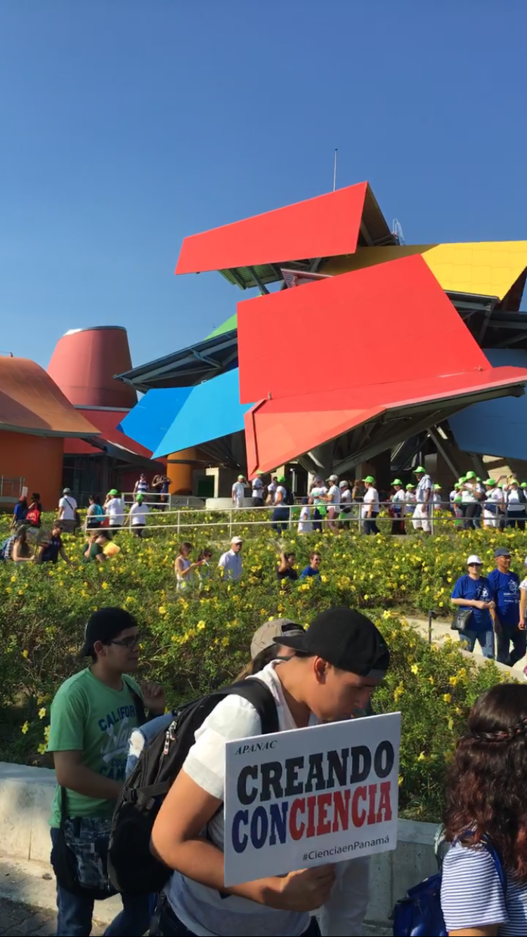 Science supporters walking down the BIOMUSEO' gardens. The BIOMUSEO is in the background. It is a colorful building desgigned by Frank Gehry.